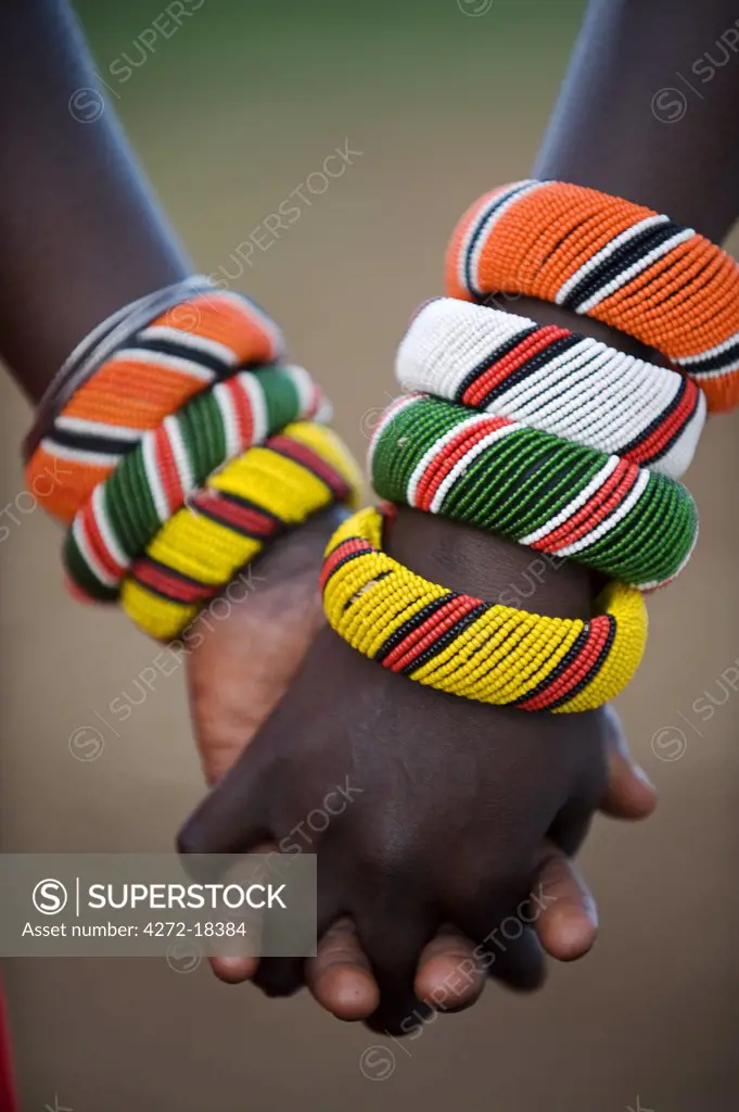 Kenya, Laikipia, Ol Malo.  A Samburu boy and girl hold hands at a dance in their local manyatta.