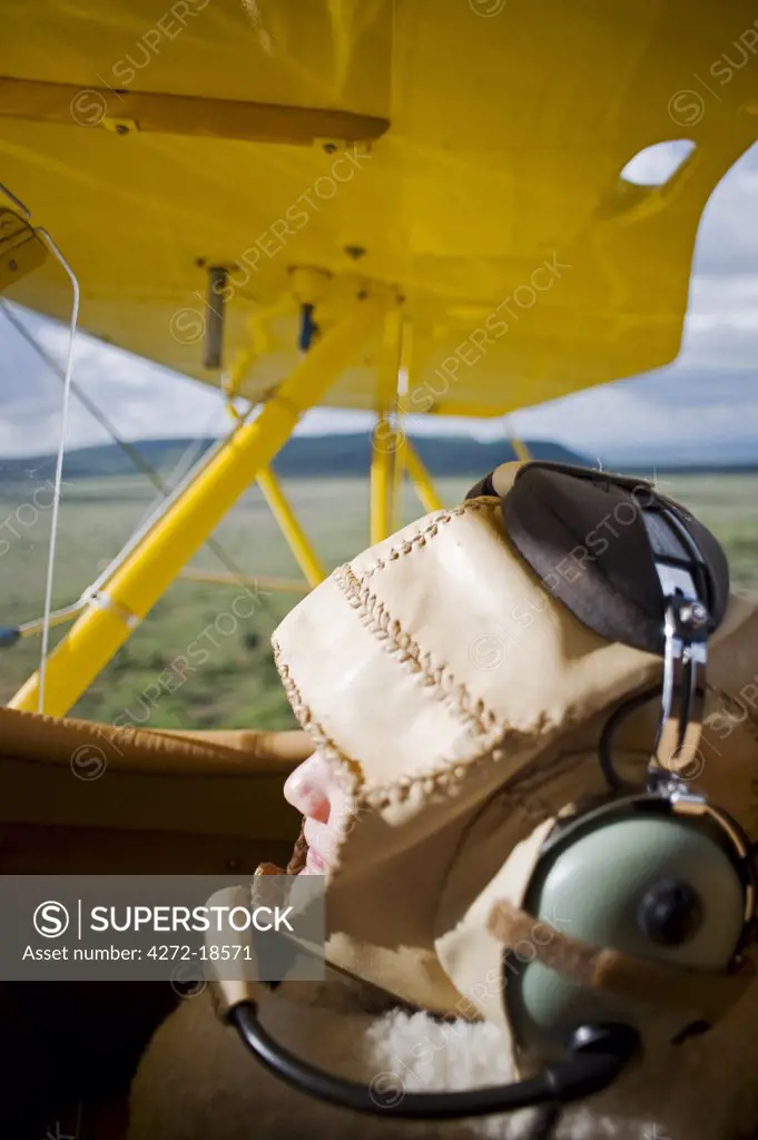 Kenya, Laikipia, Lewa Downs.  A visitoron aerial safari in the 1930s style Waco Classic open cockpit bi-plane. MR