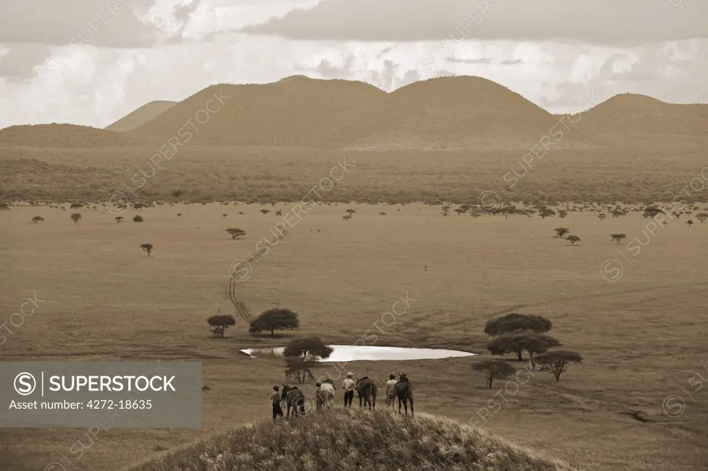 Kenya, Chyulu Hills, Ol Donyo Wuas. A family on riding safari enjoy the View out towards the Chyulu Hills.