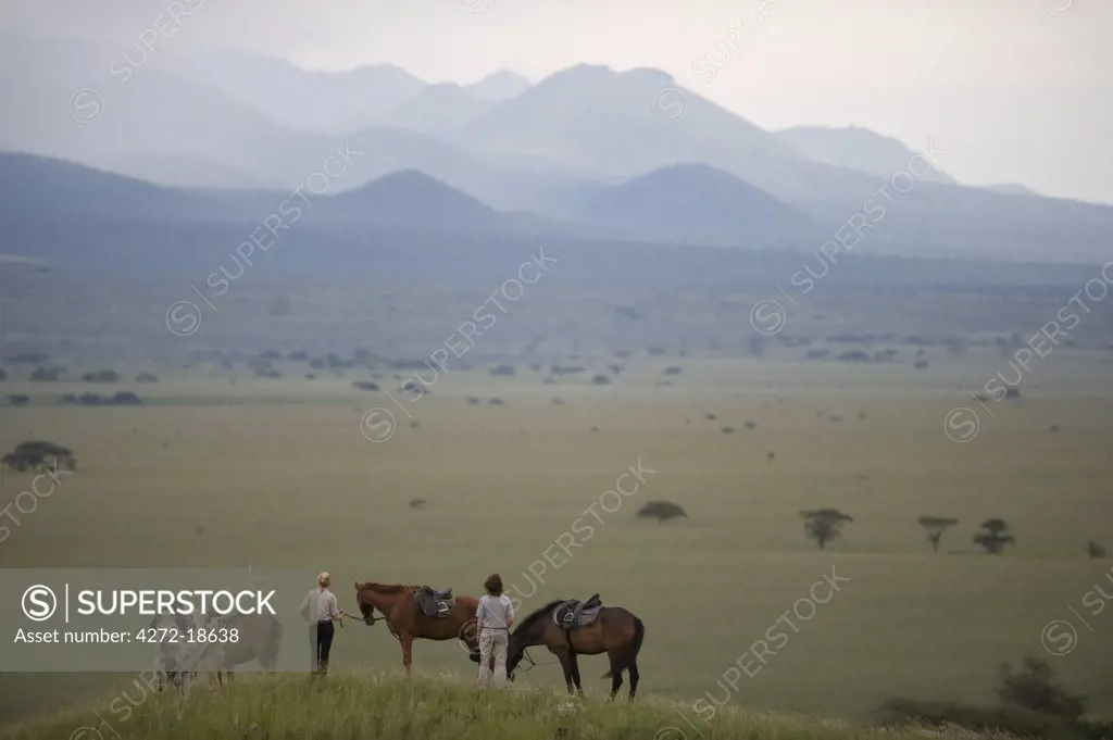 Kenya, Chyulu Hills, Ol Donyo Wuas. A family on riding safari enjoy the View out towards the Chyulu Hills. (MR)