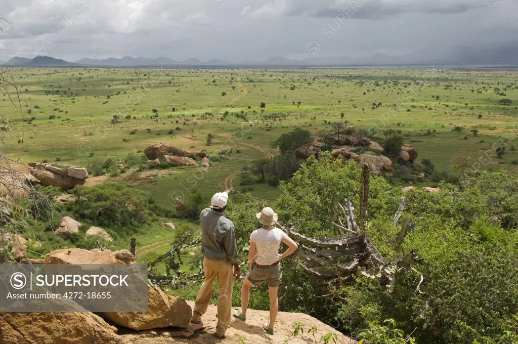 Kenya, Chyulu Hills, Ol Donyo Wuas.  Safari guide, Moses Njoroge, points out the Chyulu Hills to a guest.  (MR)