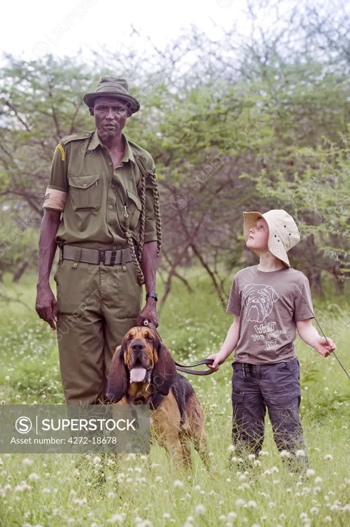 Kenya, Chyulu Hills, Ol Donyo Wuas. A boy with the anti-poaching team, Martin Ole Kirasi and his bloodhound, Bosco.