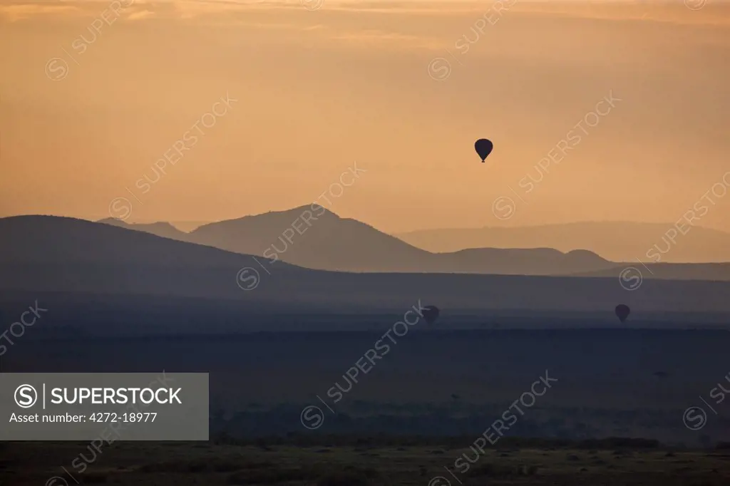 Dawn breaks over Masai-Mara as hot air balloons drift over the plains.