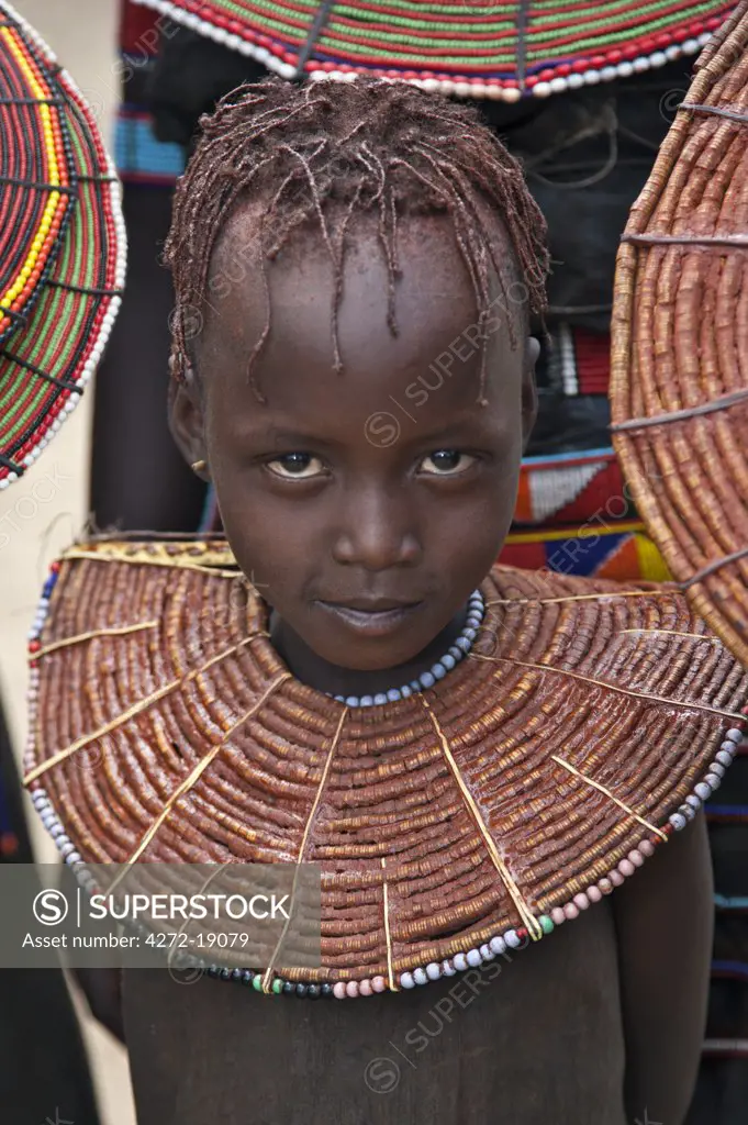 A young Pokot girl wearing a traditional broad necklace made of hollow reed grass that denotes her uninitiated status. The Pokot are pastoralists speaking a Southern Nilotic language.