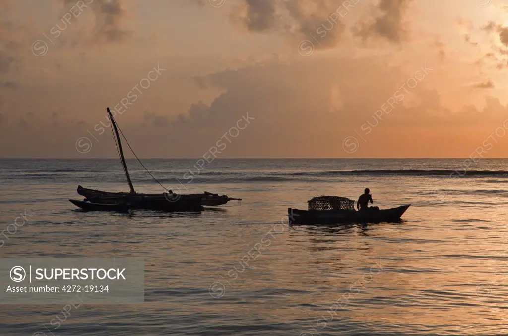 At dawn, a fisherman sets out from Msambweni, south of Mombasa, with a fish trap while an outrigger canoe is still anchored in the background.