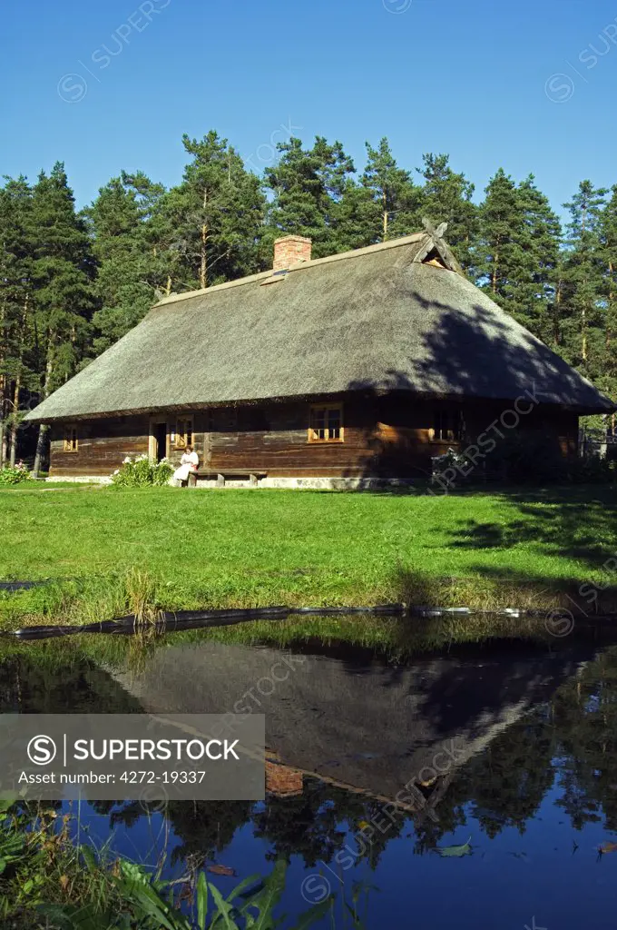 A Thatched Roof House Reflected in a Pond at the Latvian Ethnographic Open-Air Museum