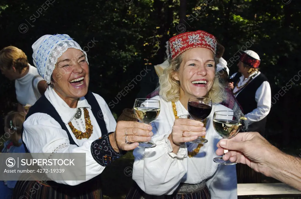 Woman in Traditional Dress enjoying Food and Wine at the Latvian Ethnographic Open-Air Museum