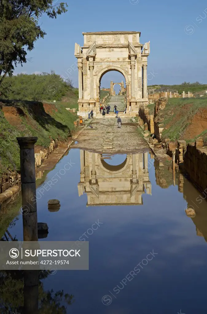 The Arch of Septimus Severus looking towards the Arch of Antonius Pius (also known as the Oea Gate), at Leptis Magna, Libya. The Arch is reflected in the flooded Decumanus Maximus.