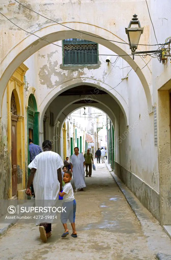 Tripoli, Libya; An African boy with his father walking through one of the streets of the old Medina of Tripoli