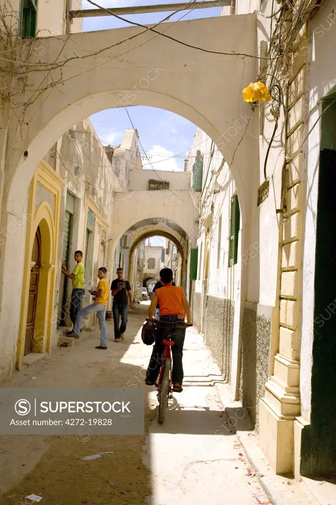 Tripoli, Libya; A youth riding a bicycle in the streets of the old Medina of Tripoli
