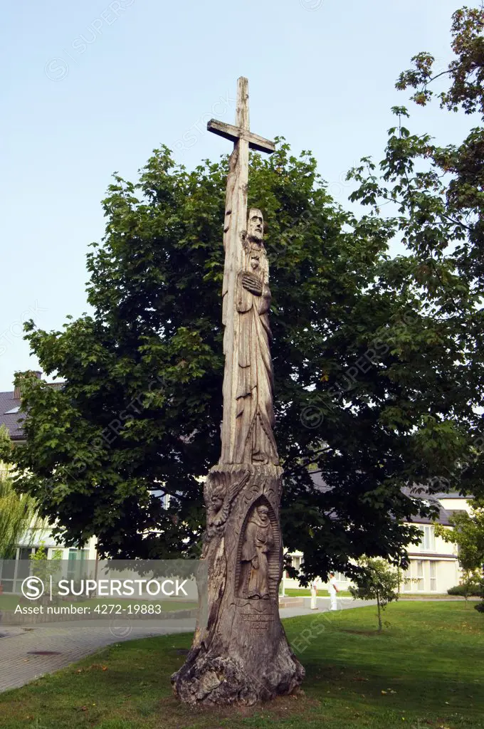 Lithuania, Curonian Spit, Juordkrante. Religious style wooden carvings located outside a local church.