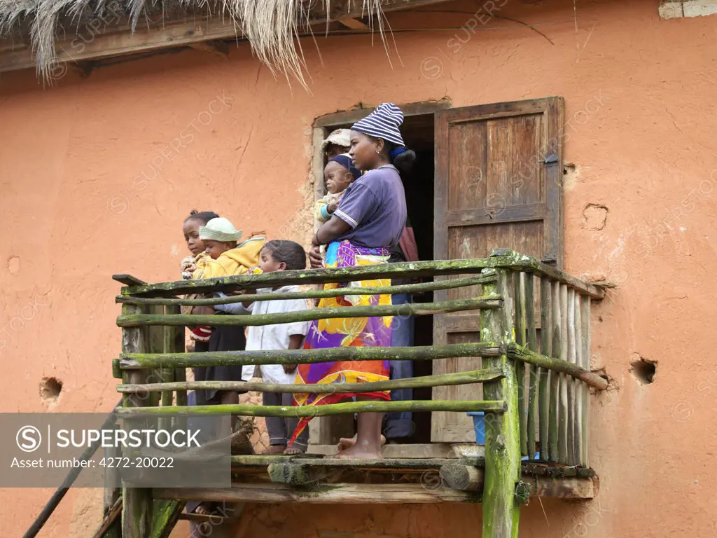 A Malagasy family stands on the balcony of their home at Ambatovaky, a village of blacksmiths not too distant from the Ranomafana National Park.