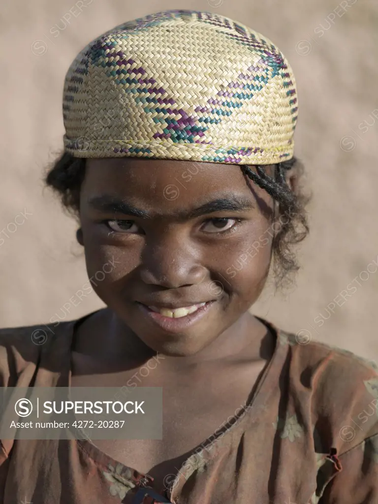 A Malagasy girl wearing a typical woven hat of the region.