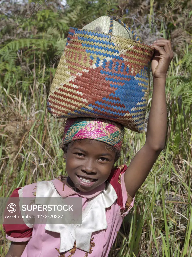 A Zafimaniry young girl walks home to Ifasina with a shopping basket on her head.