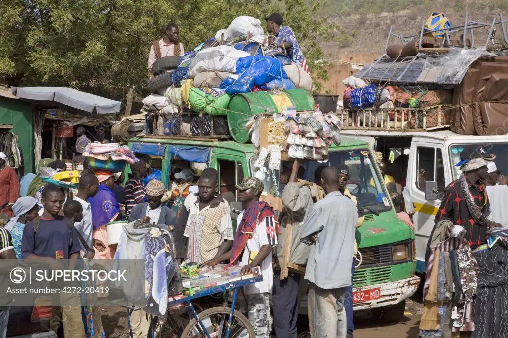 Mali, Bamako. A busy scene at one of Bamako's country bus stations where well-loaded vehicles leave for various destinations in the country when they are full.