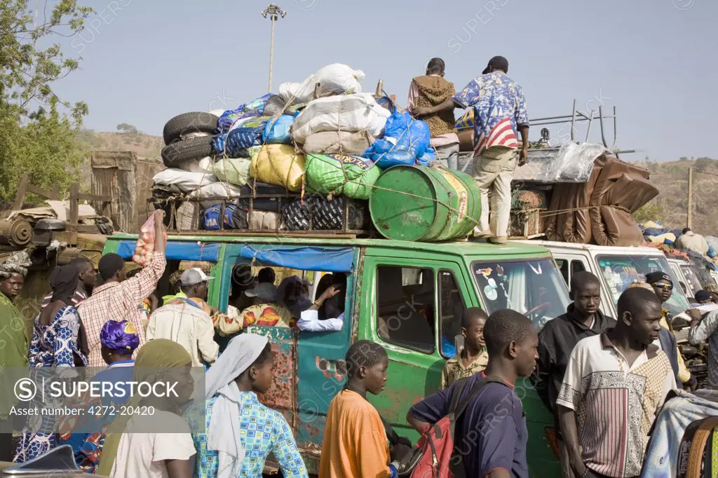 Mali, Bamako. A busy scene at one of Bamako's country bus stations where well-loaded vehicles leave for various destinations in the country when they are full.