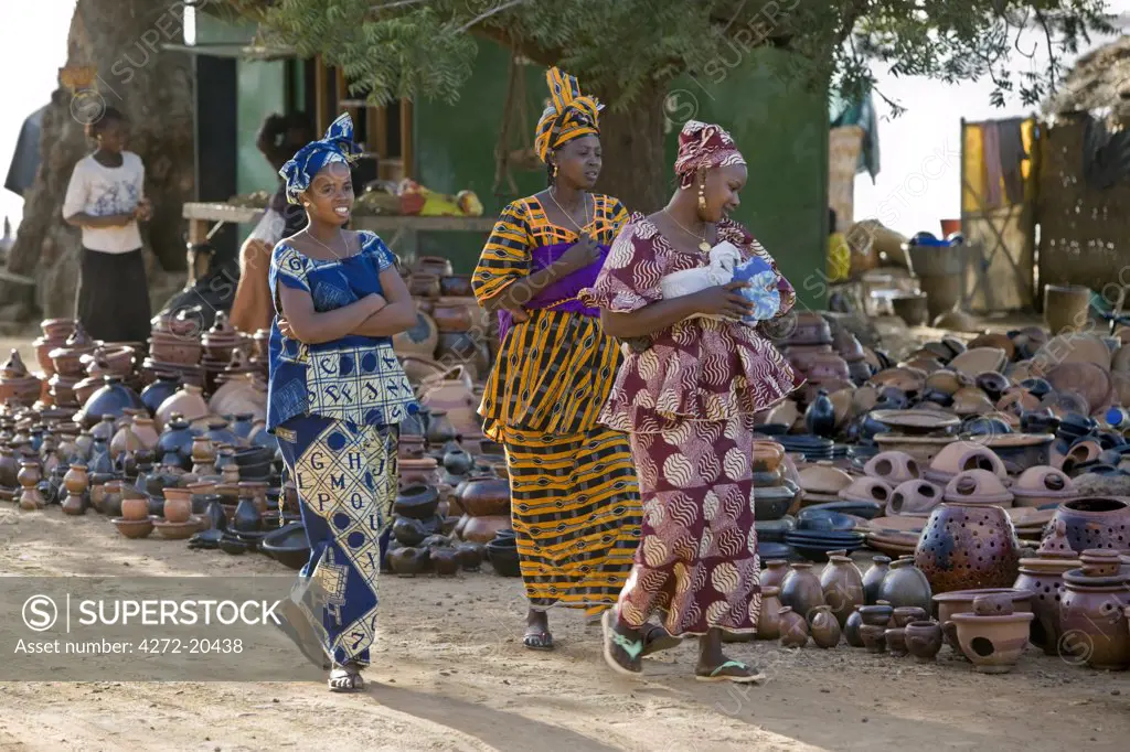 Mali, Segou, Kalabougou. Women admire a large selection of clay pots and vessels at a stall in Segou. The female potters at the nearby village of Kalabougou are renowned for their fine pottery.