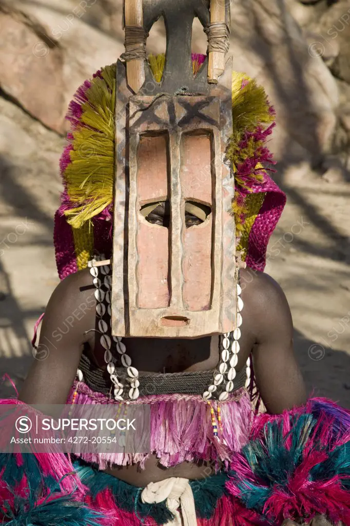 Mali, Dogon Country, Tereli. The piercing eyes of a masked dancer wearing the fifteen-foot-high Sirige mask at the Dogon village of Tereli which is situated among rocks at the base of the spectacular 120-mile-long Bandiagara escarpment.  The mask dance is staged at funeral ceremonies to appease the dead and speed them on their way to the ancestral world.