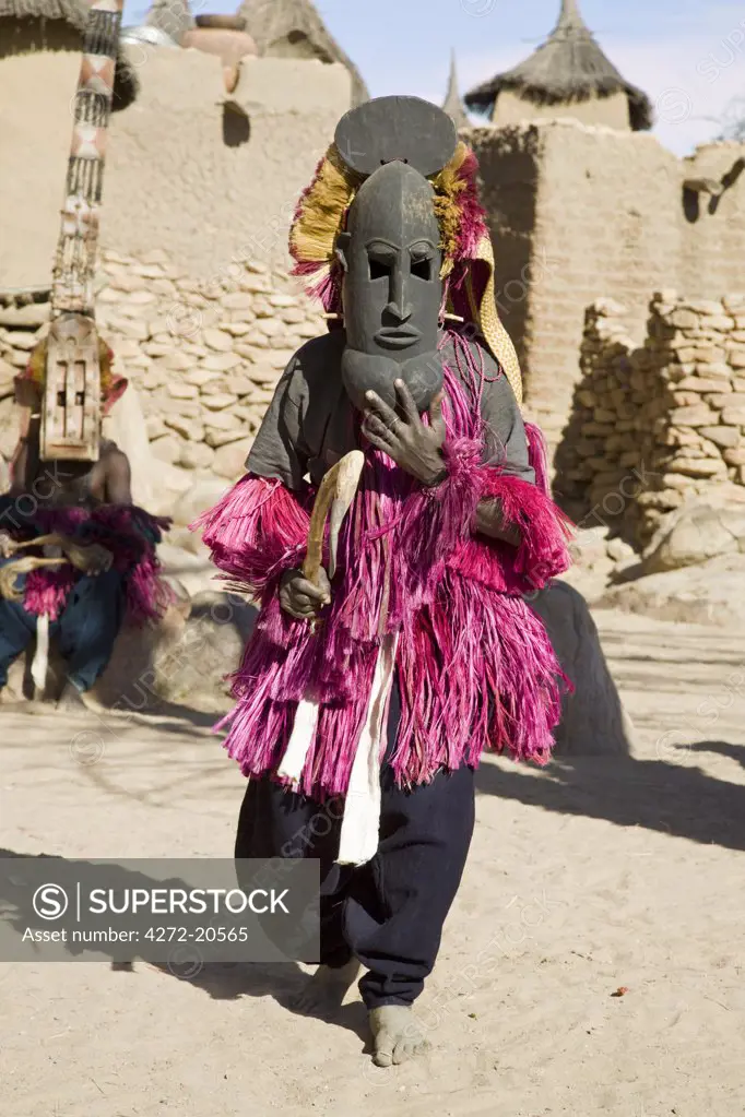 Mali, Dogon Country, Tereli. A masked dancer performs at the Dogon village of Tereli. Tereli is situated among rocks at the base of the spectacular 120-mile-long Bandiagara escarpment.  The mask dance is staged at funeral ceremonies to appease the dead and speed them on their way to the ancestral world.