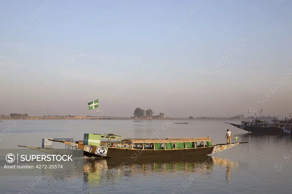 Mali, Mopti. A pinasse river boat on the Niger River at Mopti in the early morning. These comfortable boats with outboard engines take tourists and other passengers up and down the Niger River between Goa, Timbuktu, Mopti and Djenne.