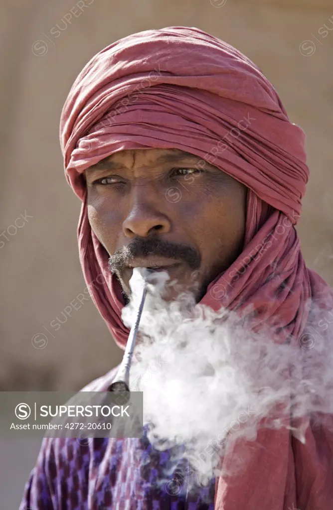 Mali, Timbuktu. A Tuareg man smokes a traditional metal pipe in Timbuktu.
