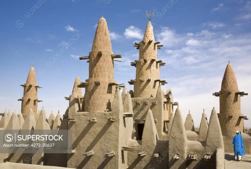 Mali, Niger Inland Delta. Dwarfed by minarets, the imam of Kotaka Mosque calls the faithful to prayers from the roof of the mosque.