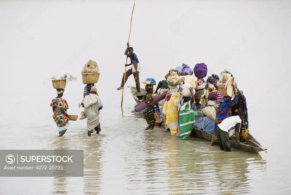People crossing the Bani river, after a market day in Djenee, a UNESCO World Heritage Site. Mali, West Africa