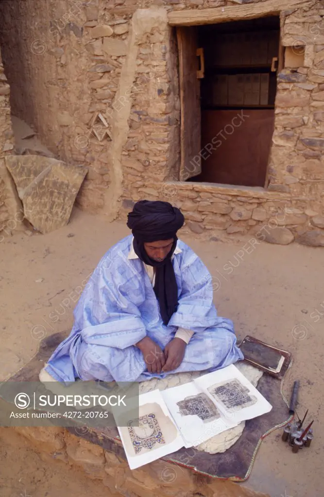 Mauritania, Adrar, The Librarian sits outside, infront of Mauritania's oldest library, and inspects some old manuscripts.