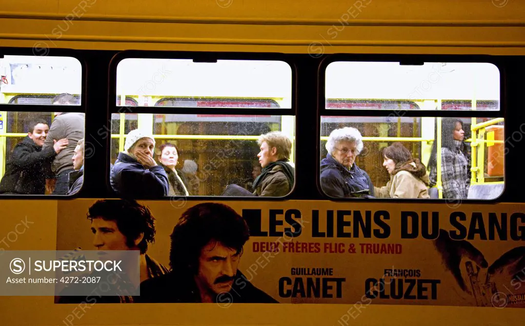 Belgium, Brussels; Passengers looking out of the window of a moving bus.