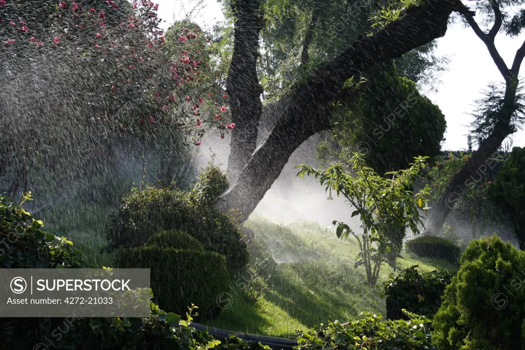 Mexico, Mexico City. Sprinklers watering gardens in Mexico City.