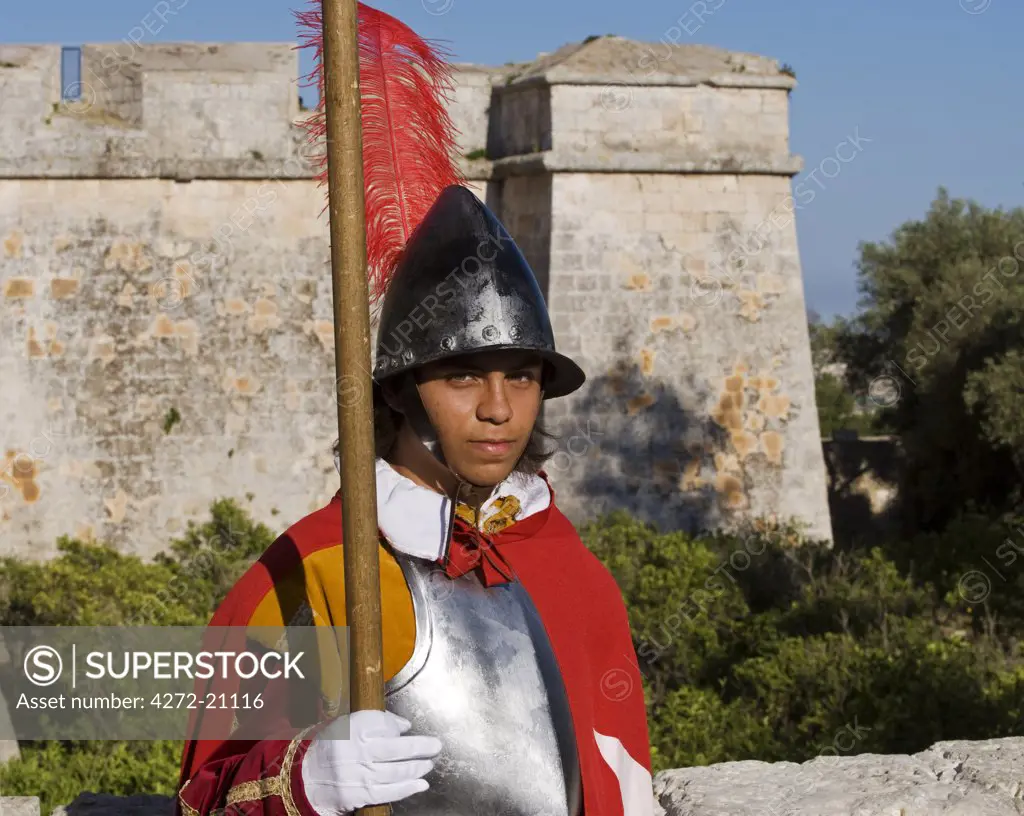 Malta, Mdina.  A guard in the historic costume of a Templar knight stands outside the entrance to the medieval walled city of Mdina.