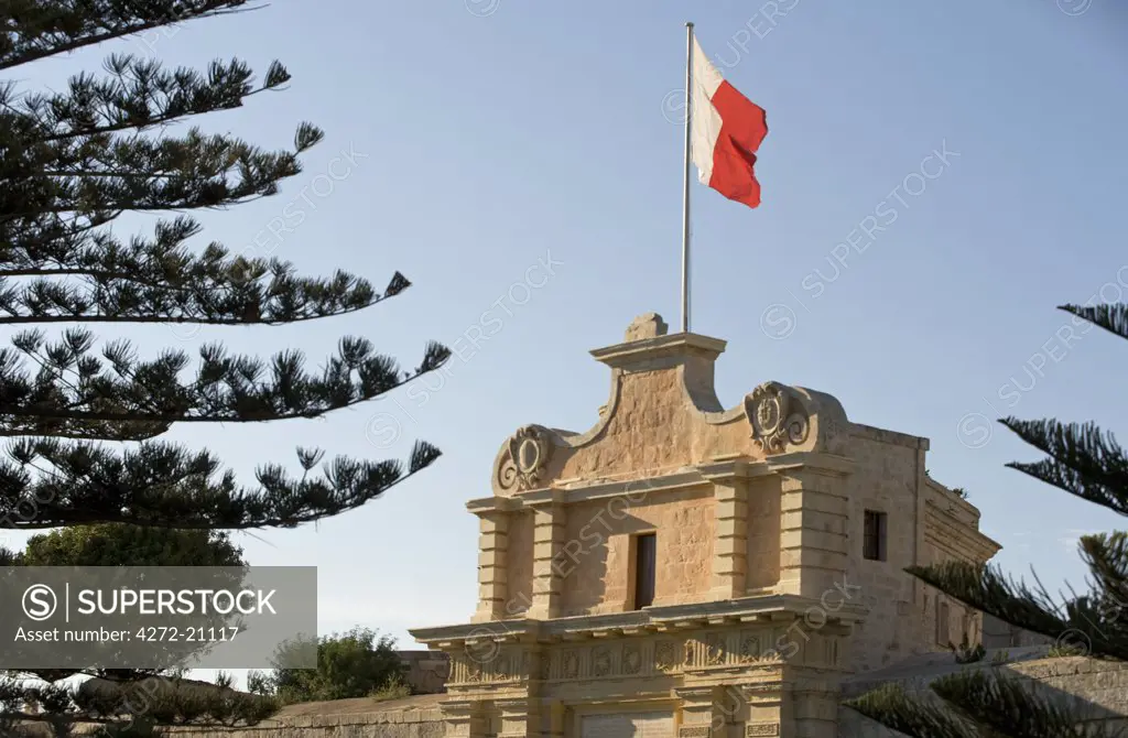 Malta, Mdina. The Maltese flag flies over the entrance to the medieval walled city of Mdina.