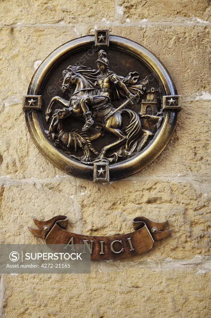 Malta, Gozo, San Lawrenz, bronze emblem of St George and the dragon with the inscription Anici outside a home in San Lawrenz.