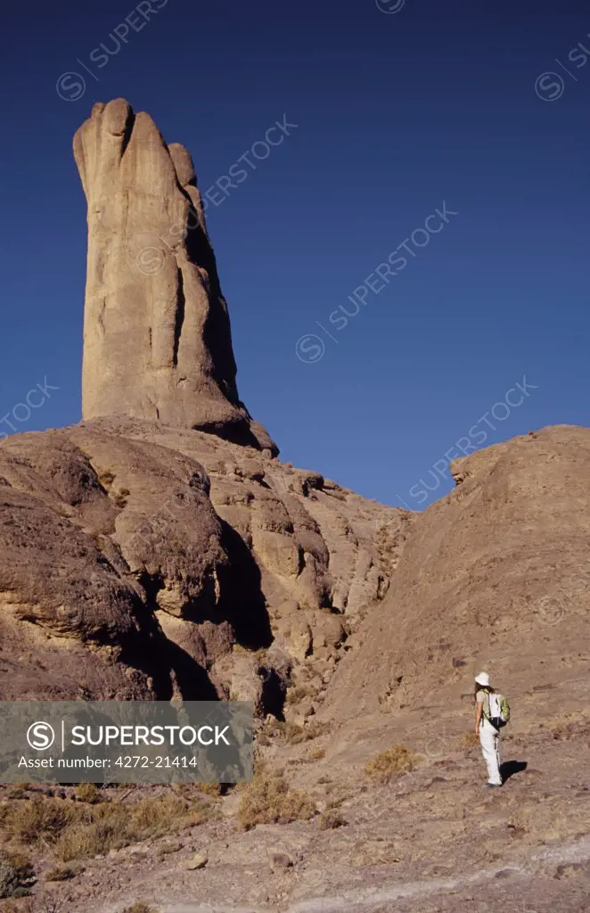 A trekker admires the impressive free-standing rock tower at Bab n'Ali. These volcanic formations in the Jbel Sahro range attracts trekkers from all over the world.