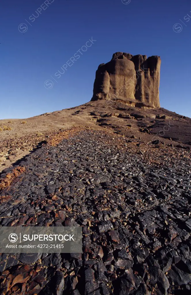 A solidified lava flow with a rock tower in background, close to Bab n'Ali. These volcanic formations in the Jbel Sahro range attracts trekkers from all over the world.