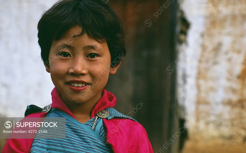Bhutanese girl in her village. Typical rural scene of terraced rice paddy fields greet visitors along the fertile Mo-Chu Valley