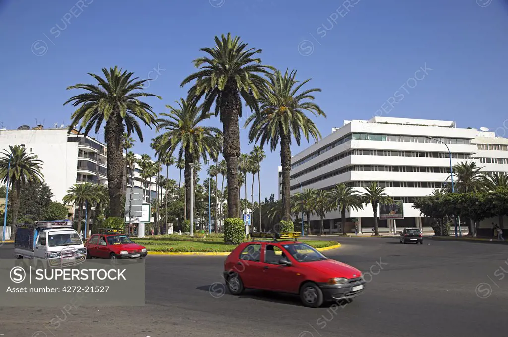 A red Petit Taxi passes through the modern business district of Gauthier in  Casablanca.