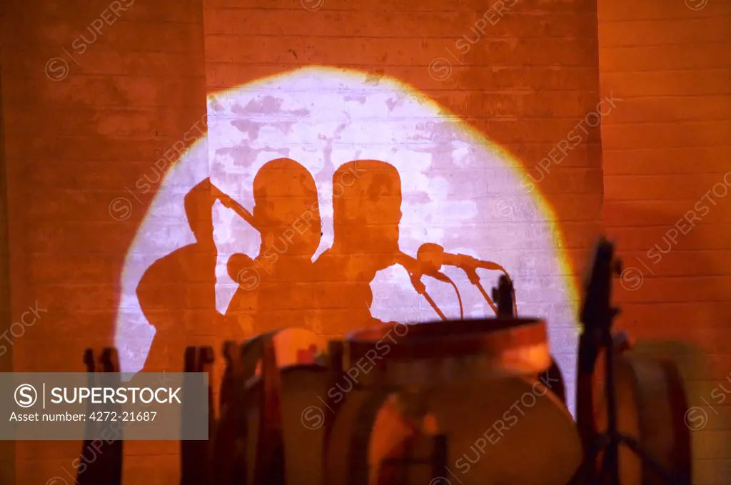 Morocco, Fes. Shadows of musicians and drums are thrown against the ancient walls of the Bab Makina during the Fes Festival of World Sacred Music.
