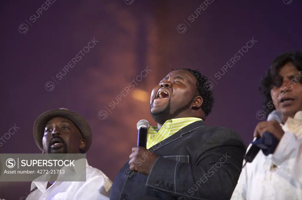 Morocco, Fes. Craig Adams on stage with Faiz Ali Faiz and a member of the Voices of New Orleans performs an encore during the Qawwali/Gospel concert at the Fes Festival of World Sacred Music.