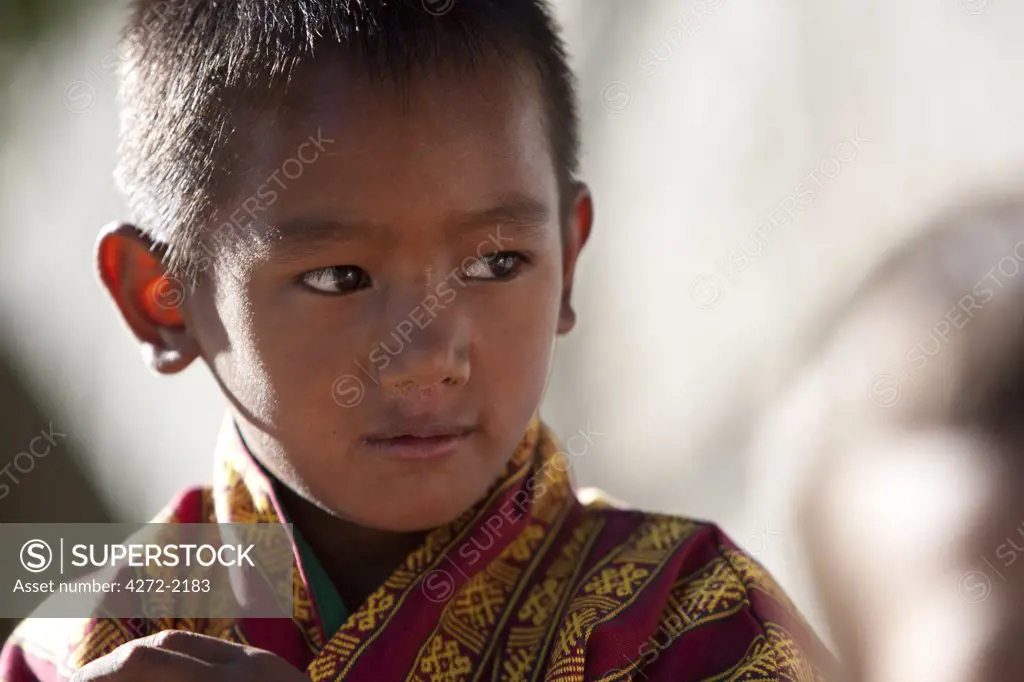 Local boy in a gho near the Phodrang Dzong in Bhutan