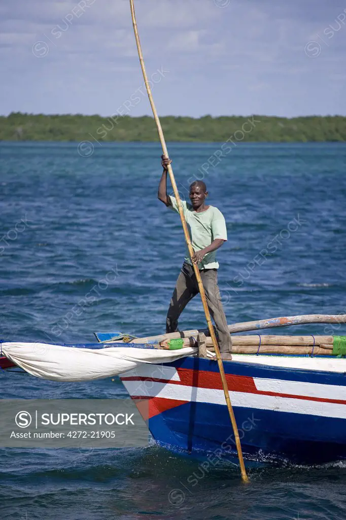A boatman guides a dhow into the harbour of Ibo Island, part of the Quirimbas Archipelago, Mozambique