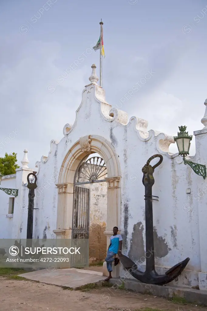 Mozambique, Ihla de Mo_ambique, Stone Town. A young man leans against the old Naval Academy in Stone Town.