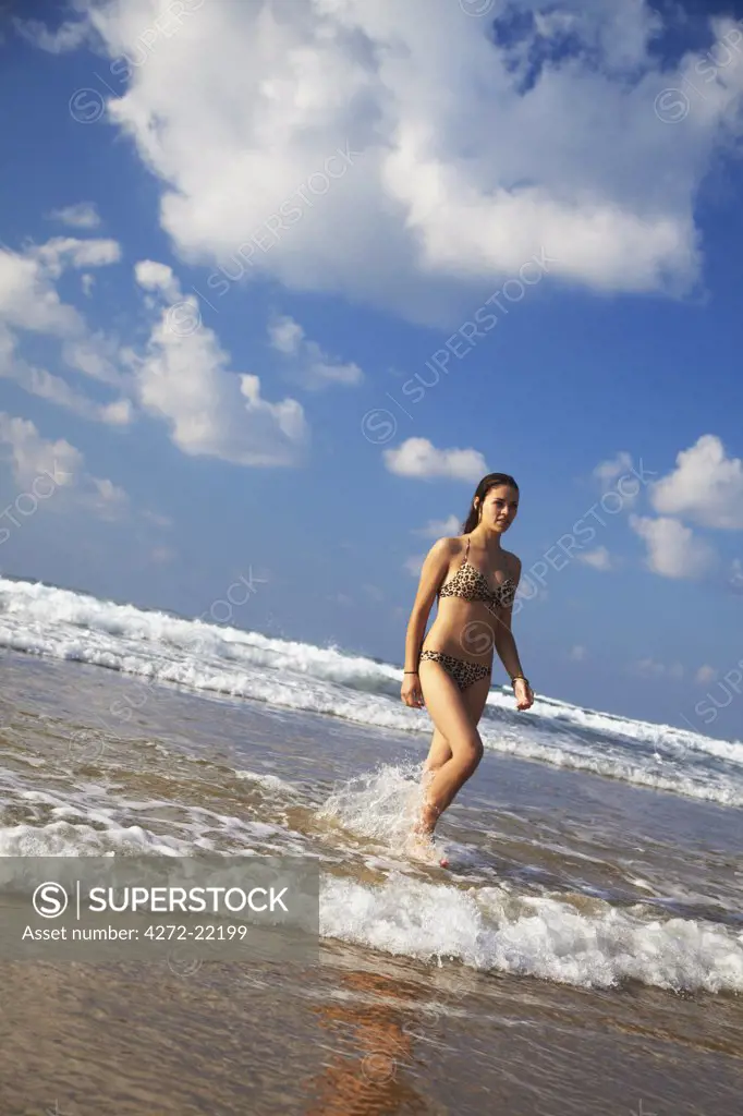 Woman walking out of sea, Tofo, Inhambane, Mozambique (MR)