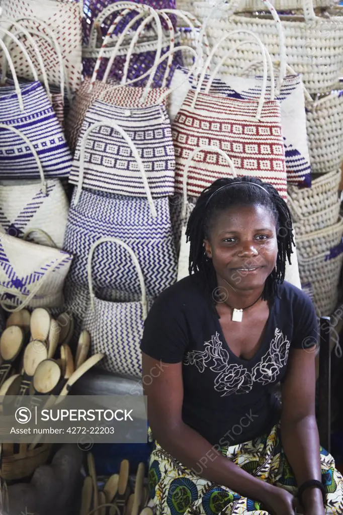 Woman vendor selling woven bags at market, Inhambane, Mozambique