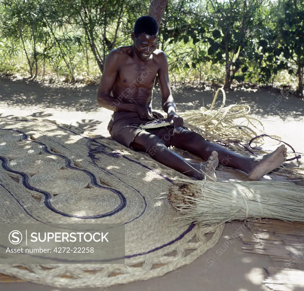A man makes attractive floor mats from dried palm fronds near Liwonde.