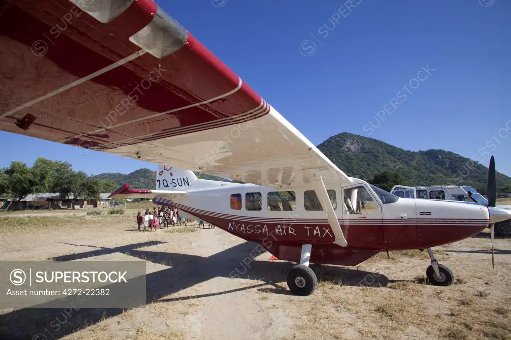 Malawi, Nyassa Air Taxi liveried aircraft waiting on bush landing strip for passengers