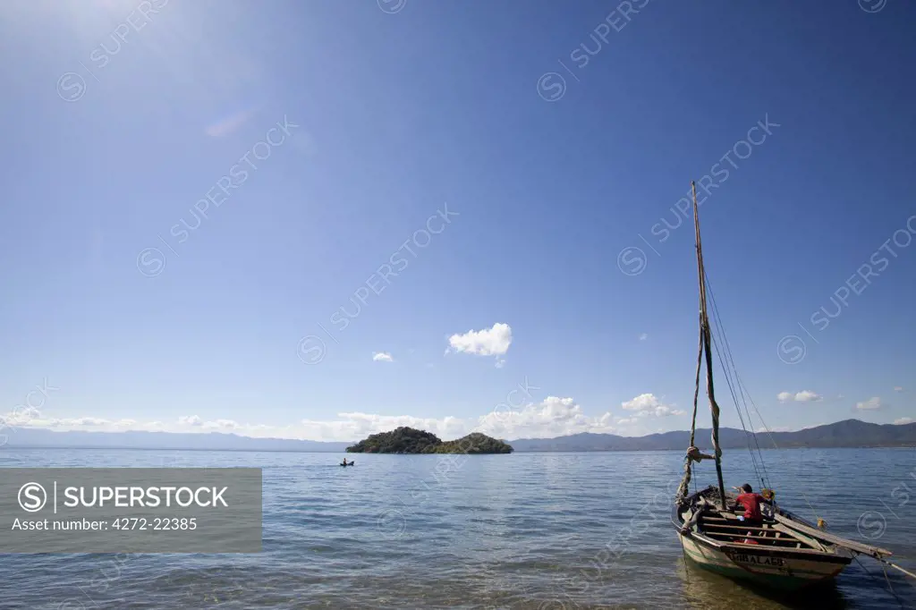 Malawi, Lake Malawi.   Fishermen in traditional wooden dhows enjoy warm sun and calm waters as they spend the day fishing