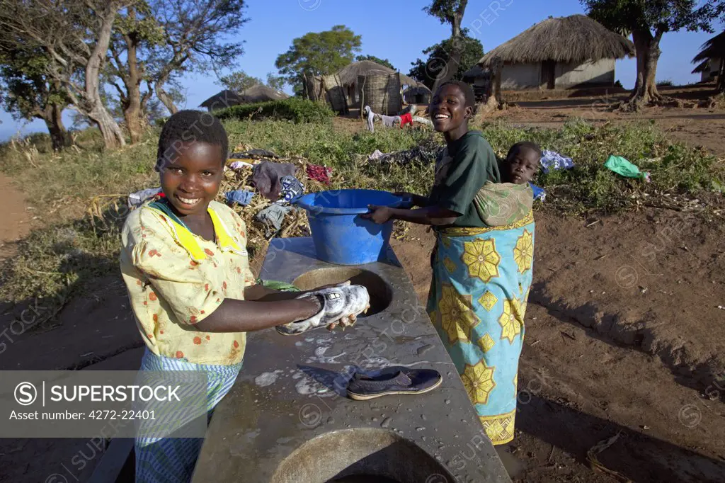 Malawi, Lilongwe, Ntchisi Forest Reserve. In a small mountain village woman gather at the communal washing area.