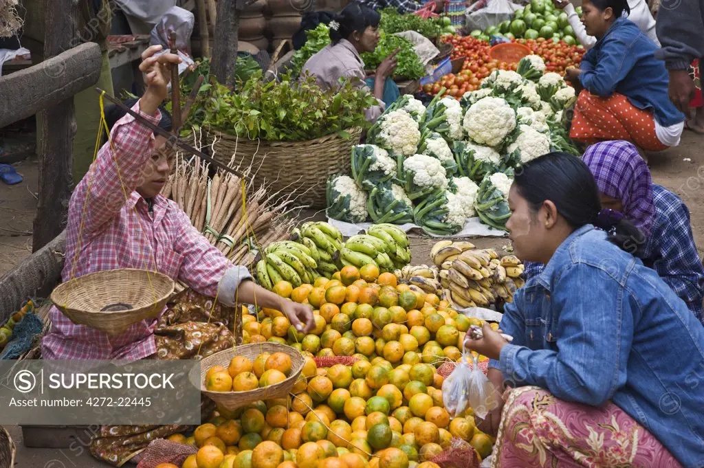 Myanmar. Burma. Nyaung U. A busy market scene with fresh fruit and vegetables at Nyaung U.  Local scales for weighing produce are commonly used.