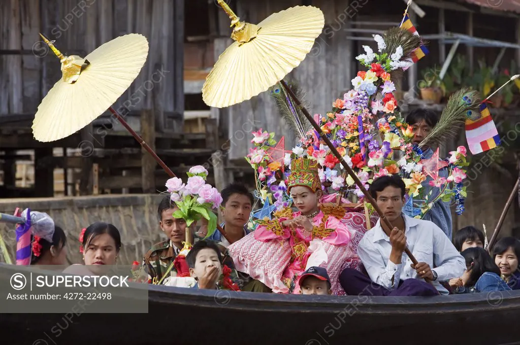 Myanmar. Burma. Lake Inle. A young novitiate with family and friends during a ceremony in which the boy is inducted as a novice Buddhist monk.